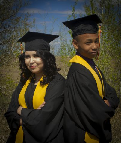 two graduates, arms crossed
