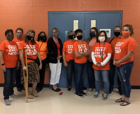 Visible support—Teachers sport orange shirts on September 30 (Suzann Self, second from right, front row). 