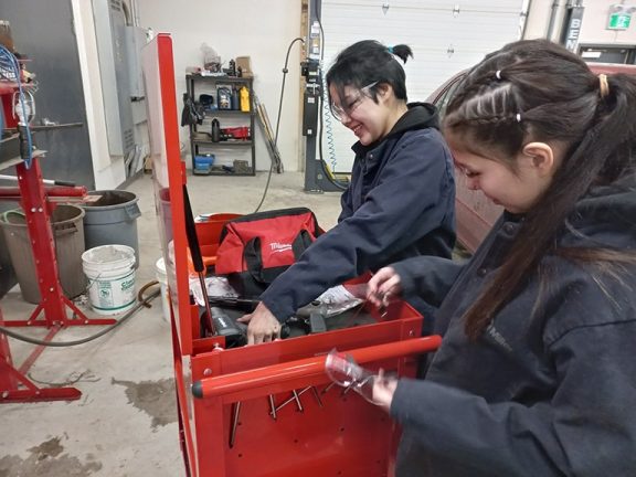 High School girls keen on auto mechanics. Photo credit: Mike Willing